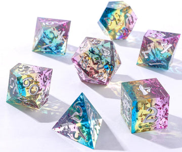 A colorful RPG dice set from Hymgho, featuring sharp-edged dice in various geometric shapes. The set includes a d20, d12, d10, d8, d6, and d4, all with translucent, rainbow-infused resin and silver numbers for easy reading.