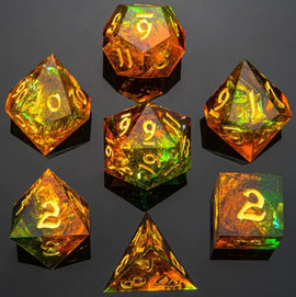 A vibrant set of seven RPG dice featuring a striking orange and green sharp edge design. Each die is prominent with golden numbers, showcasing multiple shapes including a d20, d12, d10, d8, d6, and d4. The shimmering colors reflect light beautifully, making them perfect for tabletop gaming enthusiasts.