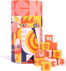 The game 'Chicken!' by Keymaster Games is showcased in a vibrant cylindrical box featuring colorful illustrations of chickens and farm elements. A playful arrangement of game cubes with various illustrations, including chickens and eggs, sits in front of the box, highlighting the fun and engaging nature of the game.