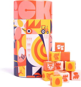 The game 'Chicken!' by Keymaster Games is showcased in a vibrant cylindrical box featuring colorful illustrations of chickens and farm elements. A playful arrangement of game cubes with various illustrations, including chickens and eggs, sits in front of the box, highlighting the fun and engaging nature of the game.
