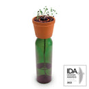 The Bottle Planter by Kikkerland is a unique and eco-friendly planter designed to repurpose a glass bottle. It features a small terracotta pot on top, holding soil and sprouts, while the green glass bottle below serves as a water reservoir. This innovative design promotes sustainable gardening by encouraging the recycling of bottles and features a charming aesthetic that enhances any indoor or outdoor space.