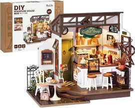 No.17 Cafe DIY Miniature House by Robotime featuring a detailed coffee shop interior. The scene includes a coffee bar with various appliances, shelves stocked with jars, a table with pastries, and decorative elements. Ideal for crafting enthusiasts aged 14 and up, this engaging DIY kit allows you to build a charming miniature cafe while showcasing intricate detailing.