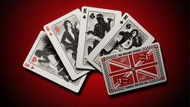 A set of Rolling Stones playing cards featuring unique designs for the Kings, including iconic imagery related to the band. The cards display a vibrant red background, showcasing the distinct band-themed artwork on each card face, and a specially designed card back featuring elements like the British flag and musical motifs.