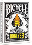 Bicycle Honeybee playing cards featuring a creative design with a yellow honeycomb structure and intricate floral patterns, emphasizing quality and craftsmanship. The packaging showcases the trusted Bicycle brand, known for its classic and innovative games since 1885.