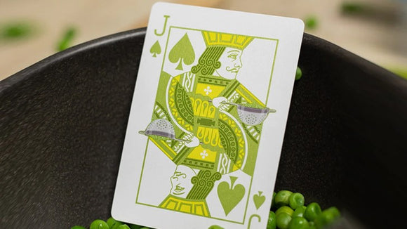 A close-up of the Jack of Spades playing card from the Sweet Peas Playing Cards set by OPC, featuring a vibrant green design and surrounded by fresh peas.