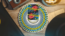 A beautifully fanned out deck of CSI Playing Cards featuring a bold crime scene design on the top card. The vibrant yellow and blue colors contrast nicely with the wooden background and vintage camera nearby, creating an engaging game-themed scene.