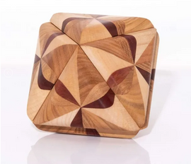 Ocvalhedron 13 by VINCO is an intricately designed mechanical puzzle made of beautifully crafted wood. The puzzle features a geometric shape with interlocking wooden pieces in various tones, showcasing a blend of light and dark wood grains. Its unique design and tactile nature make it an engaging challenge for puzzle enthusiasts and a great piece for display.