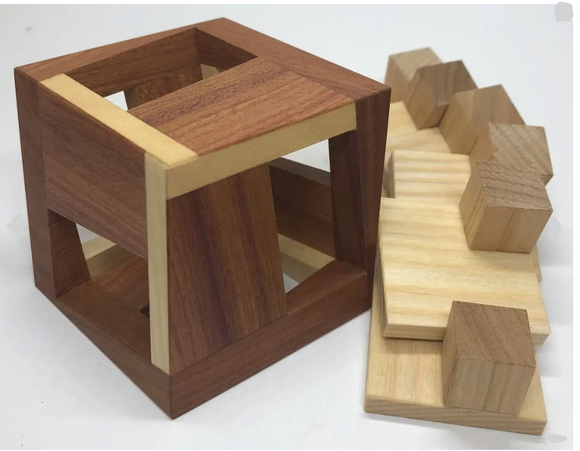EPIC by VINCO is a mechanical puzzle featuring an intricately designed wooden cube with multiple openings. It includes various wooden blocks that fit together in an engaging manner, promoting spatial awareness and problem-solving skills. The puzzle's craftsmanship showcases rich colors of natural wood, providing a visually appealing and tactile experience.