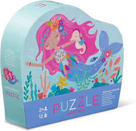 Mermaid Dreams Mini Jigsaw Puzzles by Crocodile Creek. The puzzle features a colorful illustration of a mermaid with pink hair, surrounded by sea creatures and underwater flora. The packaging is heart-shaped and vibrant, suitable for young children aged 2 and up.