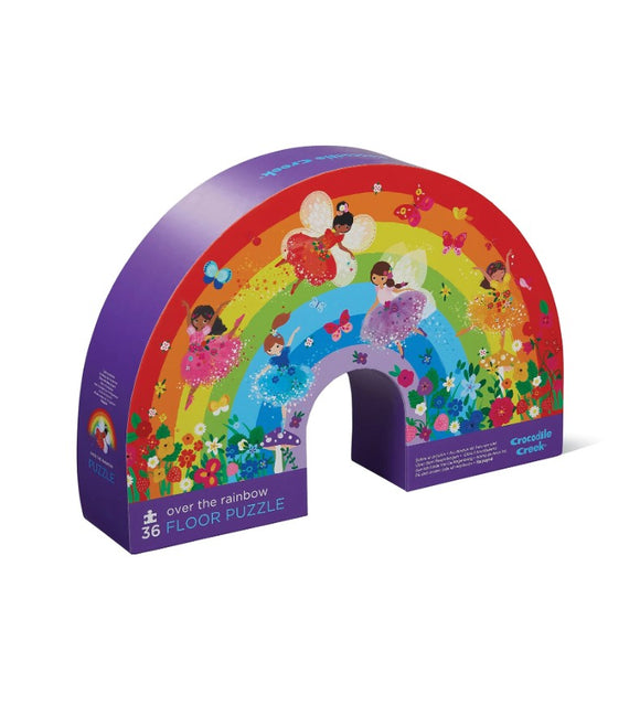 Crocodile Creek's 'Over the Rainbow' jigsaw puzzle packaging. The box features vibrant illustrations of fairies and a colorful rainbow surrounded by flowers, designed for young children.
