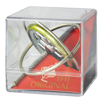 The Original TEDCO Gyroscope displayed in a clear plastic case. The gyroscope features a metallic, shiny surface with a circular ring and a handle, set against a vibrant red background that features the text 'THE ORIGINAL'.