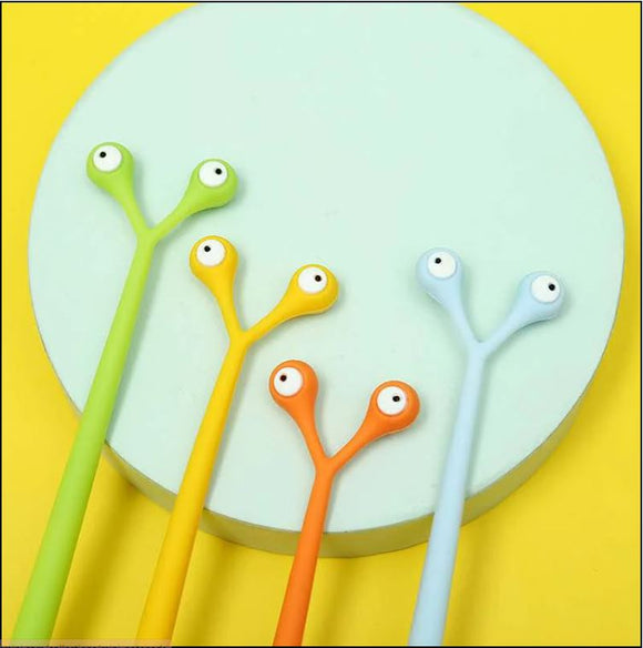 A colorful assortment of alien-shaped gel pens by BC Mini, featuring four vibrant colors: green, yellow, orange, and blue. The pens have unique designs with eyes on top and are arranged in front of a circular mint-green base on a bright yellow background, creating a playful and whimsical visual appeal.