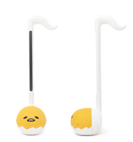The Otamatone Sanrio - Gudetama is a whimsical electronic musical instrument designed to look like Gudetama, the lazy egg character. It features a yellow round body with Gudetama's face and a long neck with a curved top, perfect for producing playful sounds. This unique instrument is great for music lovers and fans of Gudetama alike.