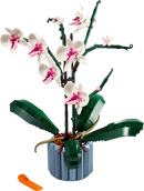 A detailed LEGO® Orchid kit featuring several vibrant white and pink orchid flowers mounted on green stems, surrounded by lush green leaves, all intricately arranged in a blue pot, showcasing the beauty of a lifelike plant creation made from colorful LEGO pieces.