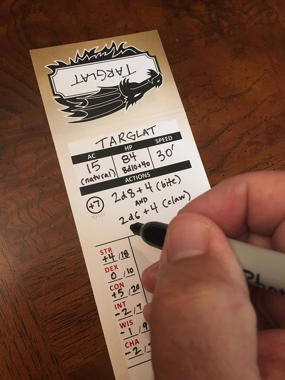 A close-up of a gaming character sheet labeled "Targlat" with game statistics, including AC, HP, Speed, and attributes written in ink. A hand holds a marker, ready to make notes on the sheet, showcasing an engaging tabletop gaming experience. The background features a wooden table surface.