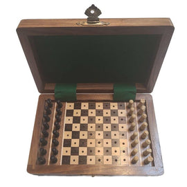 A wooden chess set measuring 4x6 inches, featuring a foldable box with a green velvet lining. The chess pieces are pegged for easy storage, displayed neatly on one side of the board. The board has alternating light and dark squares, providing a classic look for an elegant game.