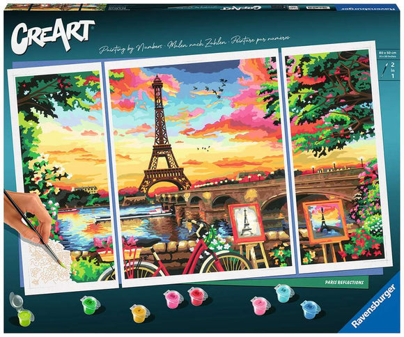 A DIY painting kit titled 'Paris Reflection' by Numb, featuring a vibrant depiction of the Eiffel Tower and scenic Parisian landscape, with tools including a brush and paint pots. The kit allows users to create a colorful artwork by following a numbered pattern. It showcases beautiful colors like pink, orange, and green in a sunset backdrop.
