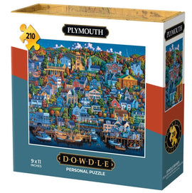 The Mini Plymouth jigsaw puzzle by Dowdle Folk Art features a colorful, detailed illustration of a quaint waterfront town with various houses, trees, and boats, presented in a sturdy box. The puzzle consists of 210 pieces and measures 9 x 11 inches, perfect for enjoyable family activities or relaxing solo time.