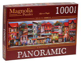 A boxed jigsaw puzzle titled 'OLD TBILISI - PANORAMIC' by Magnolia Puzzles. The box features a vibrant illustration of colorful buildings in Tbilisi, depicting intricate details and a charming, artistic style. The puzzle consists of 1000 pieces and has a five-star difficulty rating.