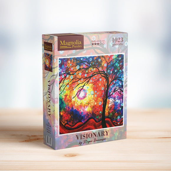 A colorful jigsaw puzzle box titled 'VISIONARY' by Magnolia Puzzles, featuring an abstract tree design with vibrant colors and circles, containing 1023 pieces. The box showcases the puzzle art with hints of orange, red, blue, and green against a vivid background, set on a wooden surface.