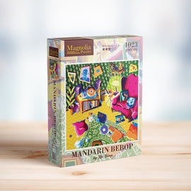 The MANDARIN BEBOP jigsaw puzzle by Magnolia Puzzles features a colorful interior scene filled with vibrant furniture, artwork, and decorative elements. The box showcases the puzzle's captivating 1023 piece design, inviting users to immerse themselves in a fun and engaging challenge while enhancing their spatial reasoning and problem-solving skills.