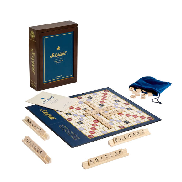 Scrabble Heritage Edition game by Winning Solutions displayed. The set includes a classic game board, wooden letter tiles, letter racks, a blue drawstring bag, and an instruction booklet. The box is elegant with a navy and gold design, emphasizing the game's timeless appeal.