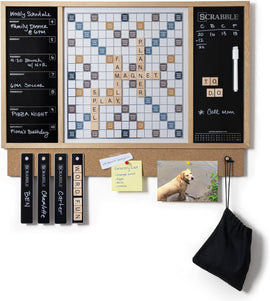 A Scrabble Message Center by Winning Solutions featuring a large Scrabble board, weekly schedule, and a corkboard section. The layout includes multiple words like 'FAMILY' and 'PLANNER' spelled out with wooden tiles, alongside a whiteboard for notes or to-do lists and a photograph of a dog. There are also grocery list notes pinned on the corkboard.