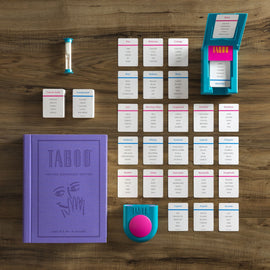 Taboo Vintage Bookshelf Game includes a purple hardcover book, a timer, and various cards laid out on a wooden surface. The game is designed for ages 12 and up and supports 4 or more players, featuring categories and clues for guessing words without using specific taboo words.