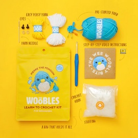 Penguin Beginner Crochet Kit by The Woobles includes colorful yarn, a yarn needle, a crochet hook, stuffing, pre-started yarn, eyes, and step-by-step video instructions. Everything is neatly packed in a bright yellow bag that holds all the supplies to create a cute penguin amigurumi.