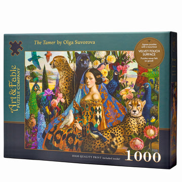 The Tamer Velvet Puzzle by Art & Fable Puzzle Co. features a colorful jigsaw artwork showing a woman surrounded by vibrant flora and fauna including peacocks, cheetahs, and various birds. The high-quality box claims it includes a luxurious velvet-touch surface and consists of 1000 pieces.