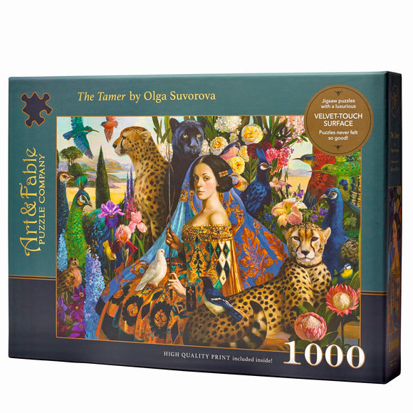 The Tamer Velvet Puzzle by Art & Fable Puzzle Co. features a colorful jigsaw artwork showing a woman surrounded by vibrant flora and fauna including peacocks, cheetahs, and various birds. The high-quality box claims it includes a luxurious velvet-touch surface and consists of 1000 pieces.