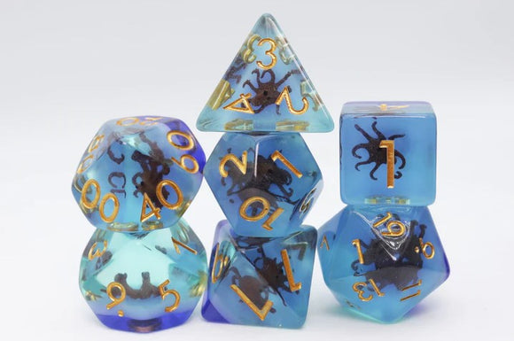 A colorful Coffee Octopus RPG Dice Set from Foam Brain Games, featuring six uniquely shaped dice including a d20, d12, and d6. The dice are transparent blue with a swirling design that showcases dark octopus figures. Each die has gold numbering, making them ideal for tabletop gaming enthusiasts.