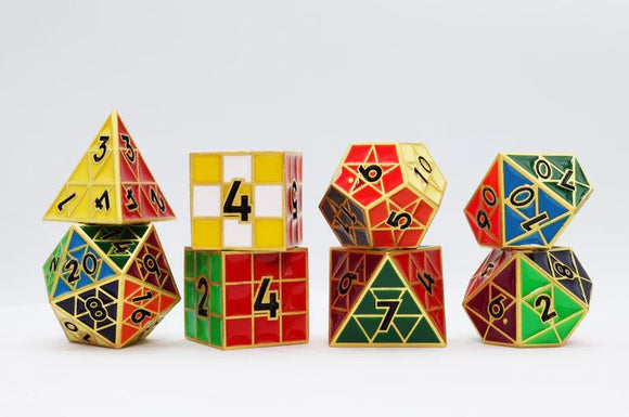 A collection of colorful metal dice in various geometric shapes, including a pyramid, cube, and polyhedron, featuring numbers in black on vibrant red, yellow, green, and blue backgrounds. These sophisticated metal RPG dice are designed for both gameplay and display.