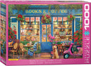 Eurographics jigsaw puzzle titled 'Books & Coffee' featuring a charming café scene. The illustration shows a cozy cafe with a blue storefront, potted flowers, and books visible through the windows. A friendly golden retriever sits at the entrance with a pink scooter nearby, creating a welcoming atmosphere. This 1000-piece puzzle captures a delightful mix of books, coffee, and pastries, perfect for puzzle lovers and café enthusiasts alike.