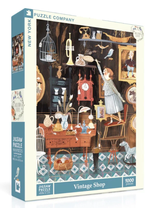 A jigsaw puzzle box featuring a detailed illustration of a vintage shop filled with various antiques and treasures. The scene includes a woman reaching for an item on a shelf, decorative furniture, and vintage collectibles, all set against a patterned floor. This puzzle consists of 1000 pieces and comes from the New York Puzzle Company.