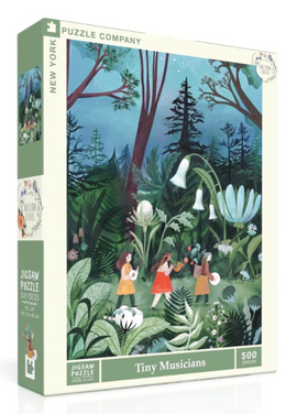 The Tiny Musicians jigsaw puzzle box features a vibrant illustration of children playing musical instruments in a lush, green forest. The artwork displays colorful flowers and trees under a night sky, creating a whimsical atmosphere. The puzzle contains 500 pieces and is made by New York Puzzle Company.