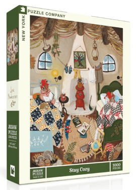 Stay Cozy jigsaw puzzle by New York Puzzle Company featuring a cozy indoor scene with two characters relaxing, surrounded by blankets, books, and a fireplace. The illustration showcases warm colors and intricate details, making it an ideal leisure activity for puzzle enthusiasts.