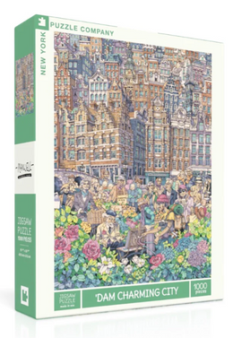 A vibrant jigsaw puzzle box titled 'Dam Charming City' by New York Puzzle Company features a detailed illustration of a bustling city square filled with people, colorful flowers, and historic buildings. The box displays the puzzle's dimensions and piece count, indicating it contains 1,000 pieces. The artwork captures charming scenes of city life, perfect for puzzle enthusiasts.
