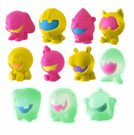 A colorful collection of 10 Nee Doh Dojee figures from Schylling. The figures are in various vibrant colors including pink, yellow, and green, featuring playful designs with smiling faces. Some figures glow in the dark, adding a fun twist to these fidget toys. Perfect for stress relief and sensory play.