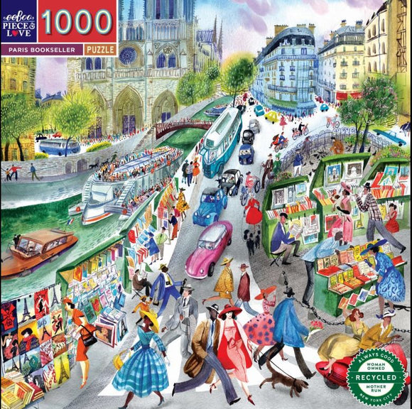 A vibrant and colorful jigsaw puzzle featuring a busy Parisian street scene. People dressed in stylish outfits stroll past book stalls filled with books, while cars and bicycles navigate the streets beside a river. The backdrop includes beautiful architecture and greenery, capturing the essence of Paris culture.