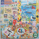 Colorful 1000-piece jigsaw puzzle featuring seabirds and coastal scenery. The puzzle design includes vibrant illustrations of birds, flowers, and marine life, set against a backdrop of a lighthouse and boats. The artwork showcases a mix of artistic elements, such as photographs and drawings, surrounded by various crafting supplies.