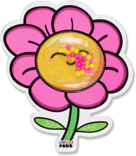A colorful Jelli Pods Flower with a smiling face and vibrant pink petals. The center contains small yellow and pink gel-like pods that create a fun sensory experience. The flower design is backed by green leaves, making it visually appealing for all ages.