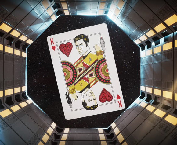 A vibrant playing card featuring illustrations of characters from Star Trek, specifically a King of Hearts design. The card is set against a futuristic space-themed background, highlighting its unique Star Trek design elements and colors.