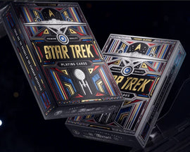 A display of Star Trek Light Playing Cards designed by Theory 11. The two decks feature vibrant, colorful artwork with iconic Star Trek imagery, including the Starship Enterprise and Starfleet insignia, emphasizing their premium quality. The cards are presented in elegant packaging that reflects the beloved sci-fi theme.