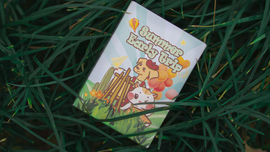 Playing card titled 'Summer Early Trip' featuring whimsical illustrations of a dog, a cat, and colorful balloons against a green grass backdrop. Perfect for summer-themed games with friends and family.