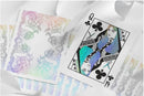A close-up view of the Innocence Holographic Playing Cards by WJPC, featuring vibrant holographic designs and intricate illustrations on each card. The image displays the Queen of Clubs card prominently, showcasing unique color gradients and artistic detailing that make these cards stand out in any game.