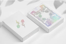 Innocence Holographic Playing game by WJPC, featuring a beautifully designed box with a holographic cover and floral motifs. Packaging is elegant with soft pastel colors, showcasing intricate illustrations, perfect for game nights.