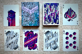 City of Mirrors Playing Cards by TCC Fashion. The deck features vibrant, futuristic illustrations on each card, including complex structures in bold colors. The card box is visually striking, displaying the title 'City of Mirrors' with an intricate urban cityscape design.