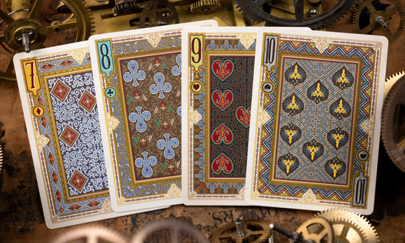 A close-up of Alice in Wonderland playing cards featuring ornate designs in gold, blue, and red. The cards display numbers 7, 8, 9, and 10, showcasing intricate artwork and unique patterns, surrounded by vintage gears.