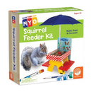 The MYO Squirrel Feeder Kit by MindWare features a colorful box showcasing a DIY kit for children aged 5 and up. The packaging displays a cheerful illustration of a squirrel and a small, red and yellow picnic-style feeder complete with an umbrella, along with paint and decorative elements. The text 'Build, Paint & Decorate' emphasizes its creative, hands-on approach for young crafters.
